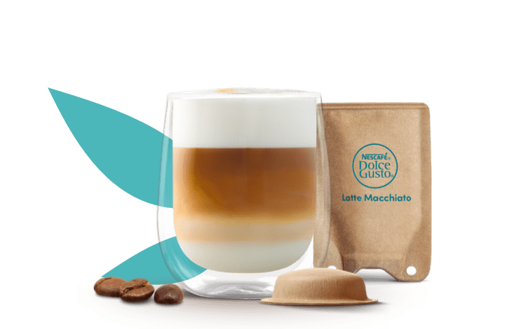 kop met latte macchiato naast een composteerbare pad en sachet