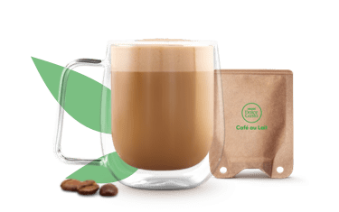 koffie met melk in een tas naast een sachet op papierbasis